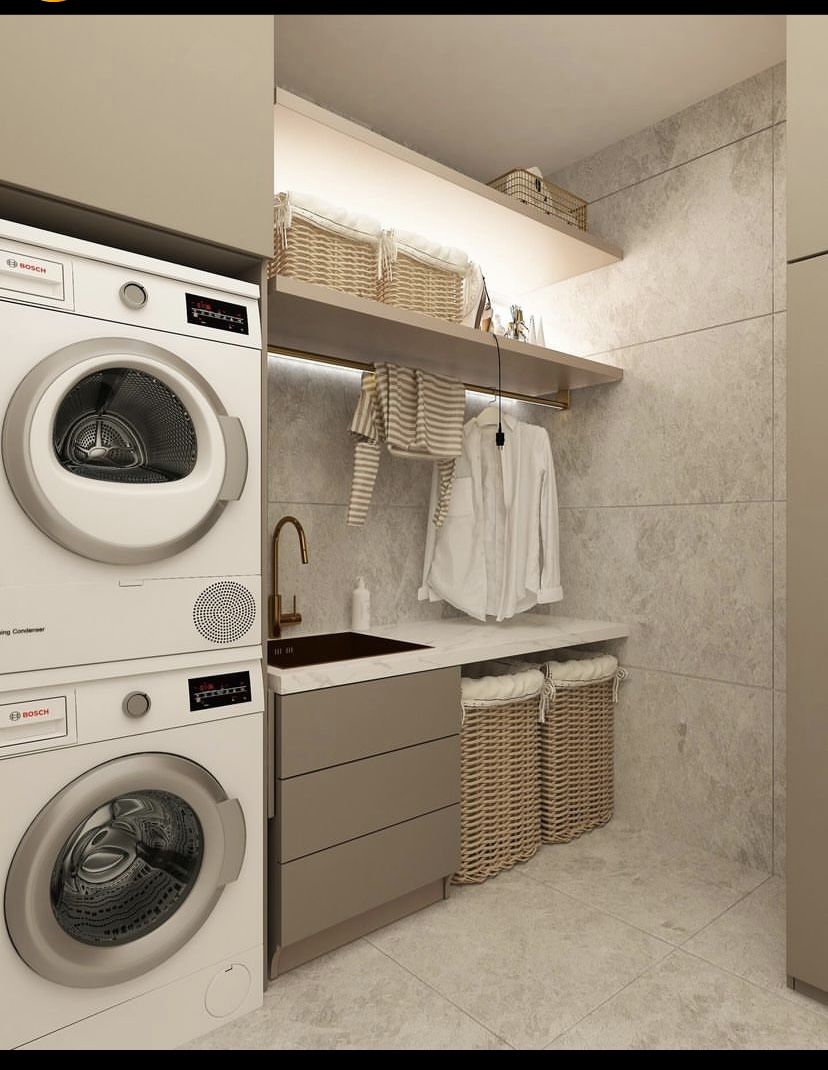 Modern laundry room with stacked Bosch appliances, sink, and woven storage baskets | Al Janah Al Malaky