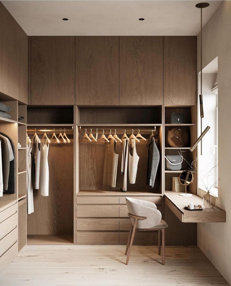 Custom walk-in closet with warm brown wood cabinets, open hanging space, and vanity desk | Al Janah Al Malaky