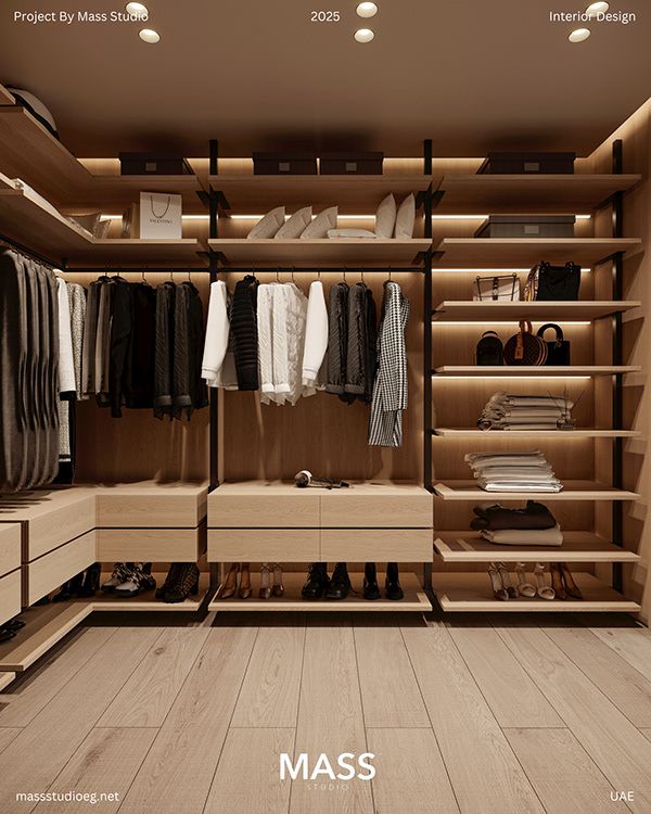 Custom light wood walk-in closet with organized clothing and backlit shelves | Al Janah Al Malaky