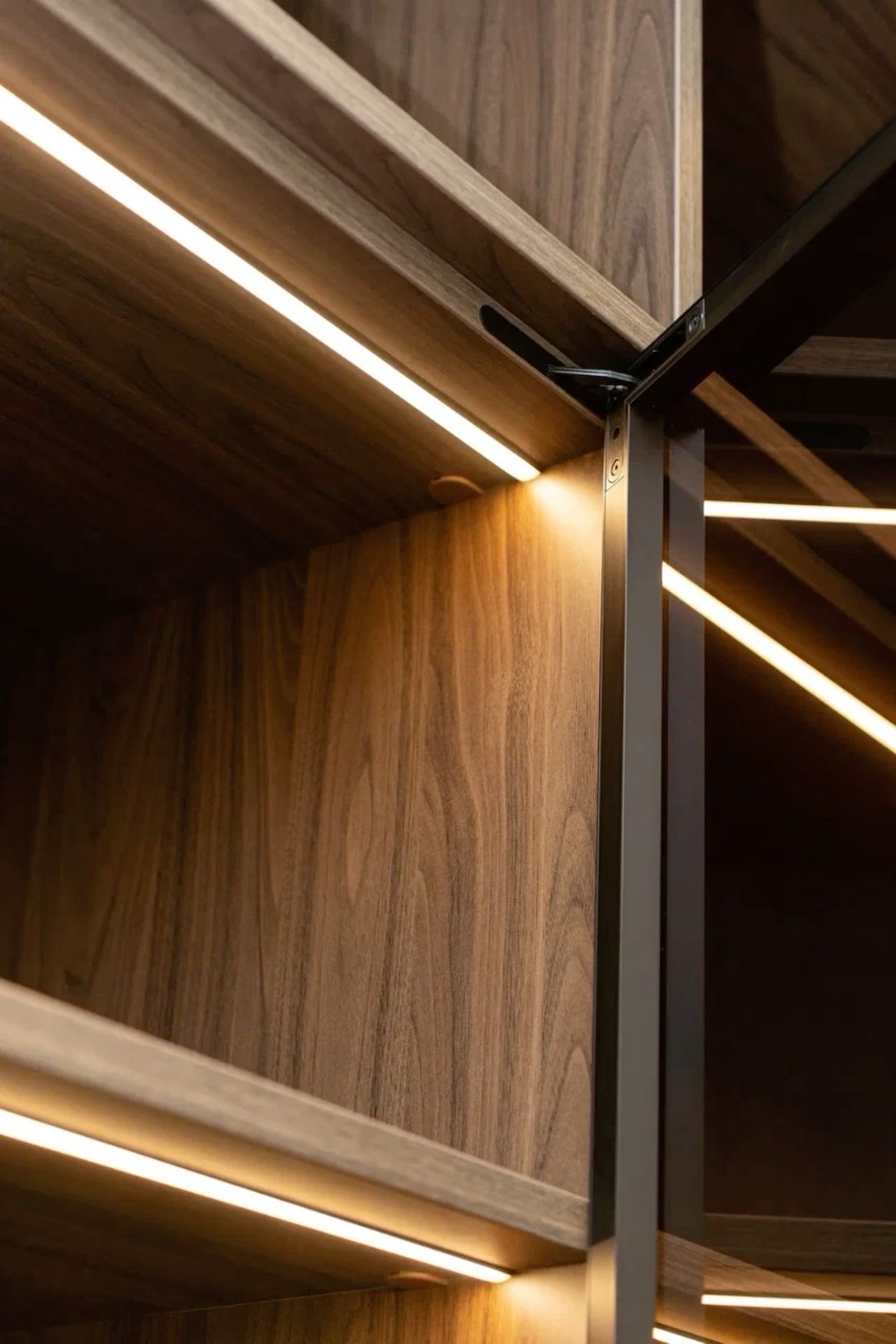 Dark stained wood grain and illuminated shelving detail with metal frame | Al Janah Al Malaky