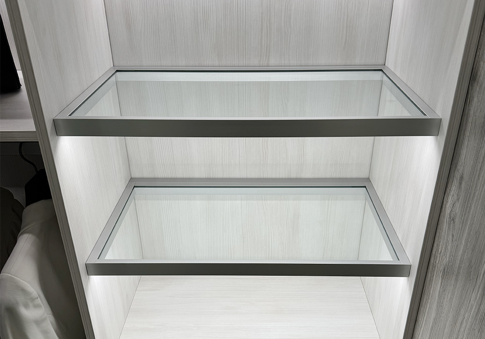 Two illuminated glass shelves with metal frames inside a cabinet | Al Janah Al Malaky