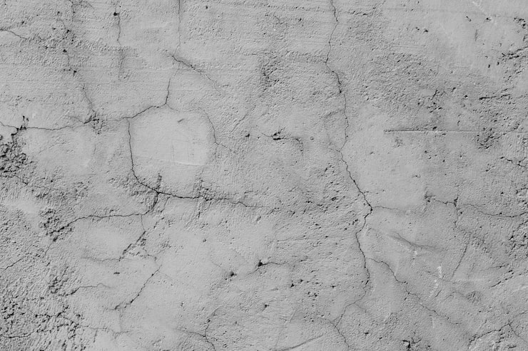 A textured grey concrete wall with many cracks | Al Janah Al Malaky