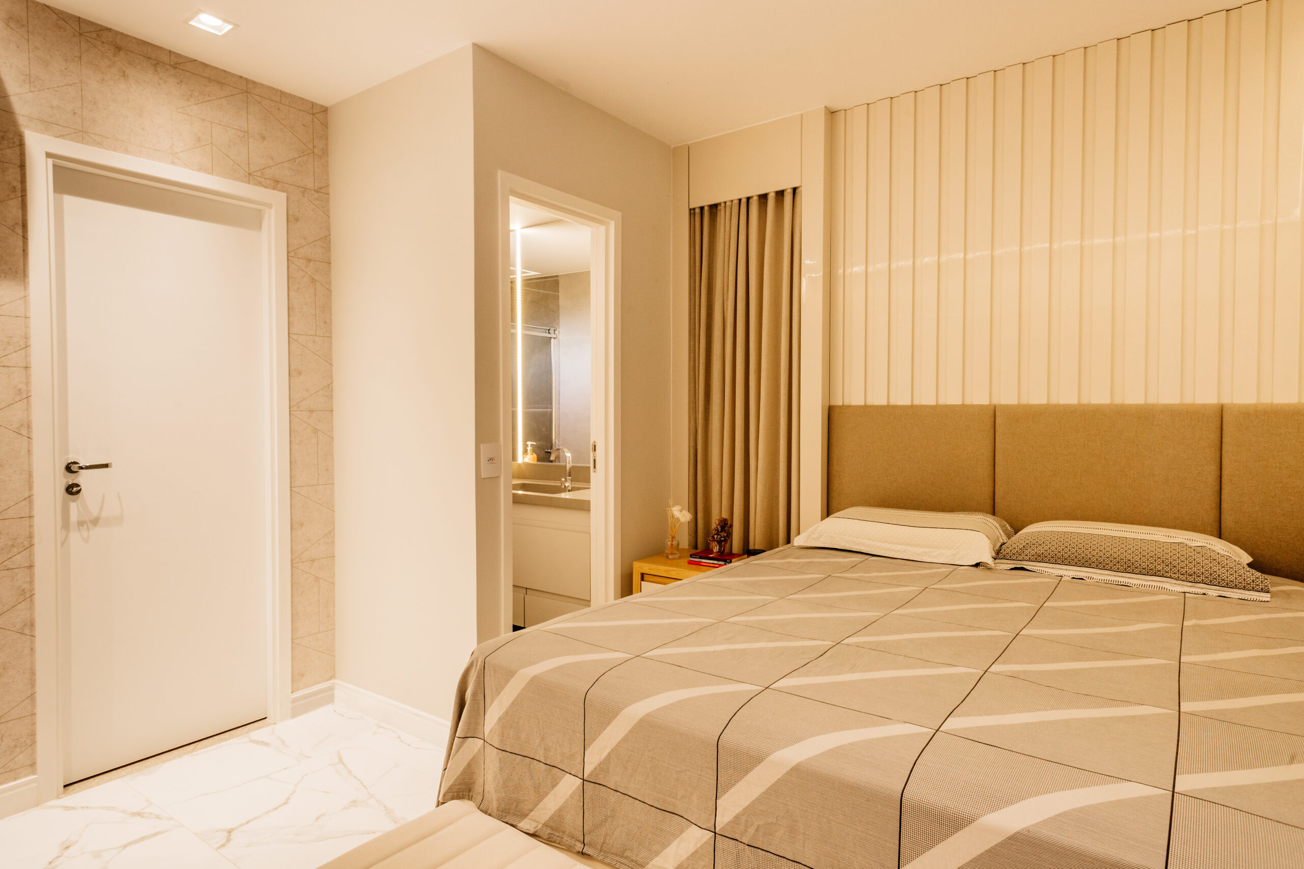 A modern bedroom with a neutral color palette and en-suite bathroom | Al Janah Al Malaky
