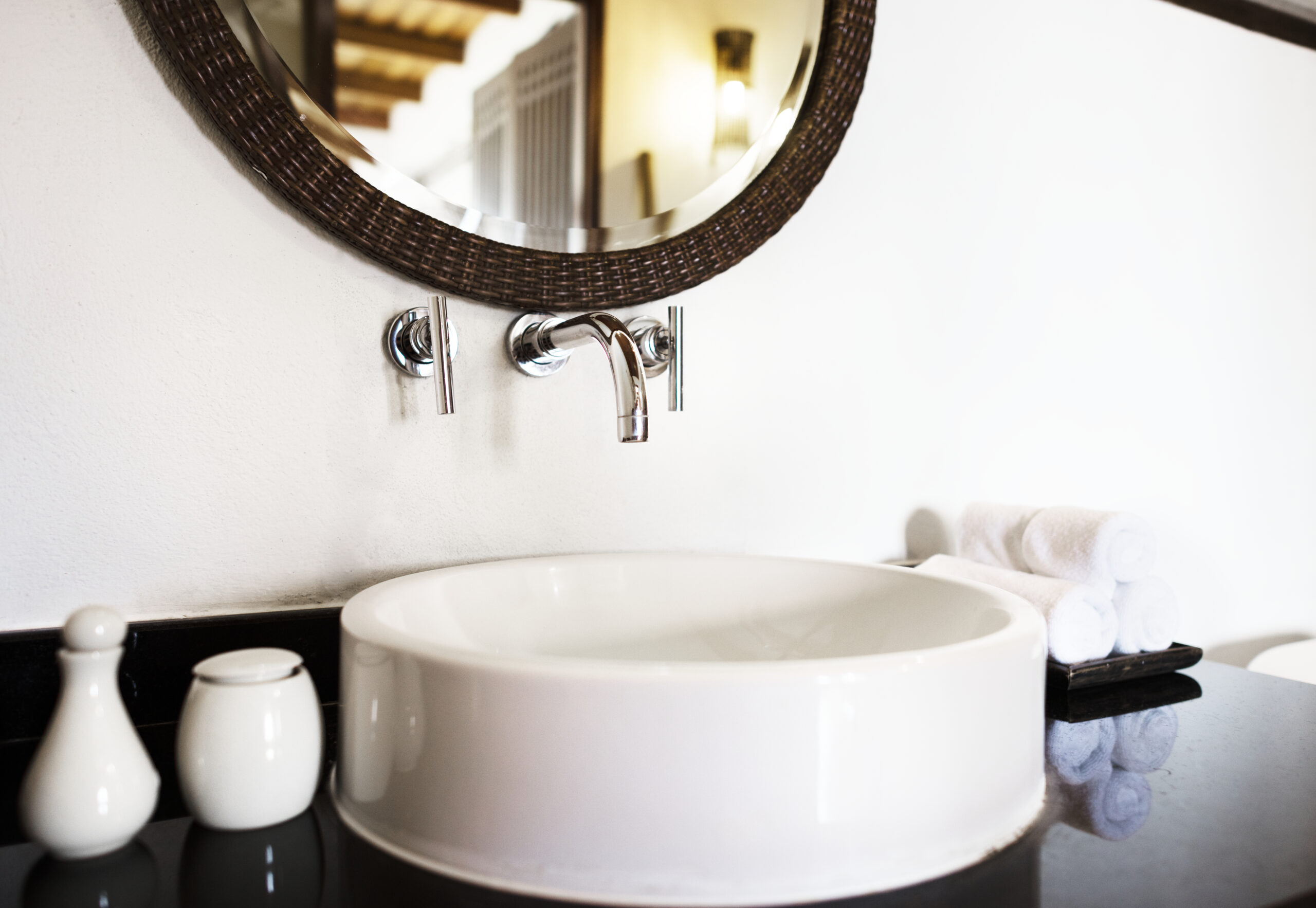 A modern bathroom sink with a soap dispenser and towels | Al Janah Al Malaky