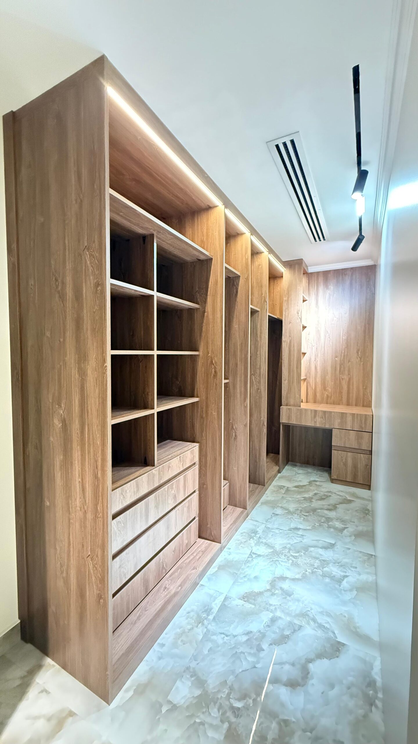 Al Janah Al Malaky: Modern white bedroom with a built-in wardrobe and lighted vanity.