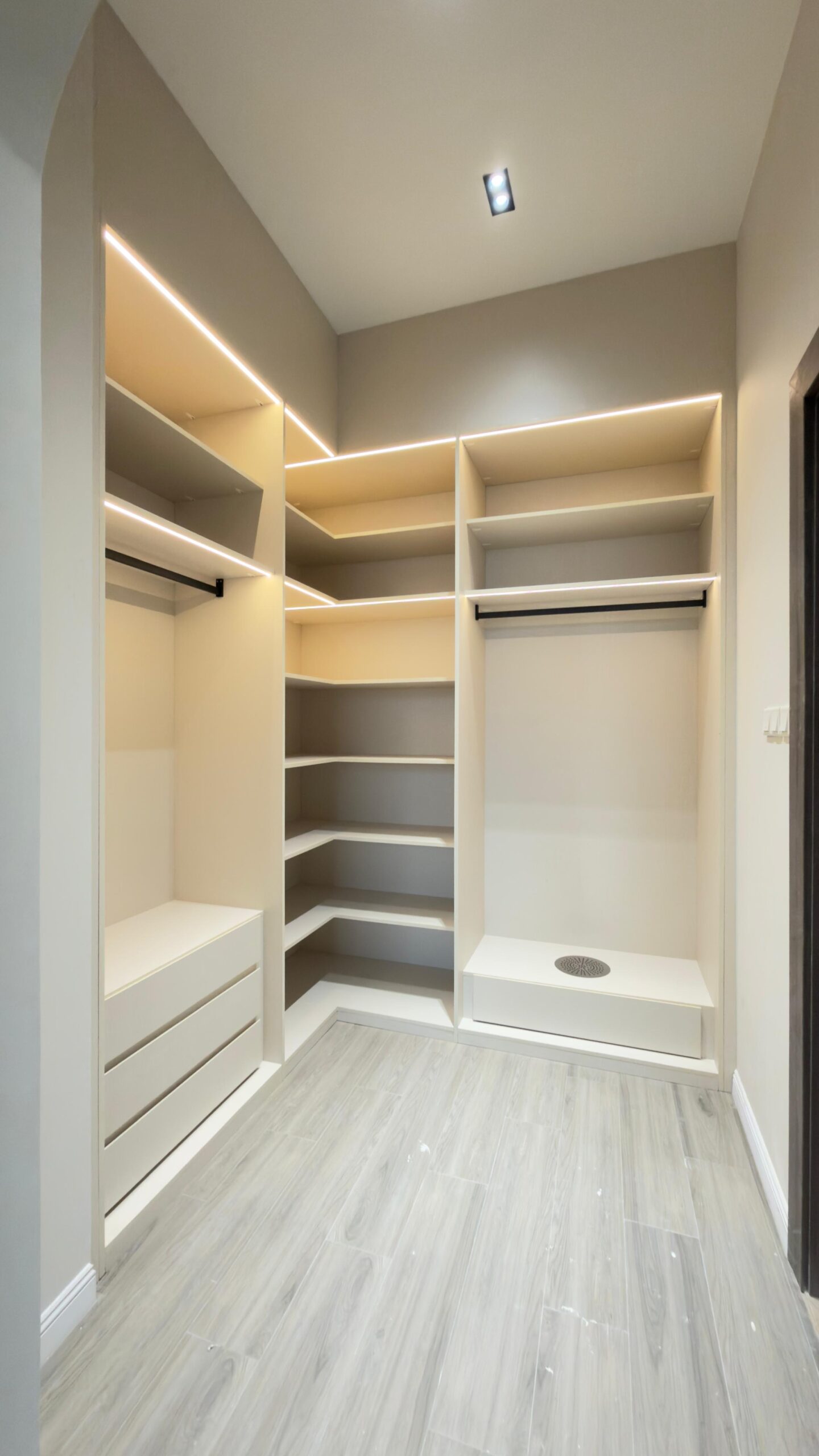 Al Janah Al Malaky: Modern white bedroom with a built-in wardrobe and lighted vanity.